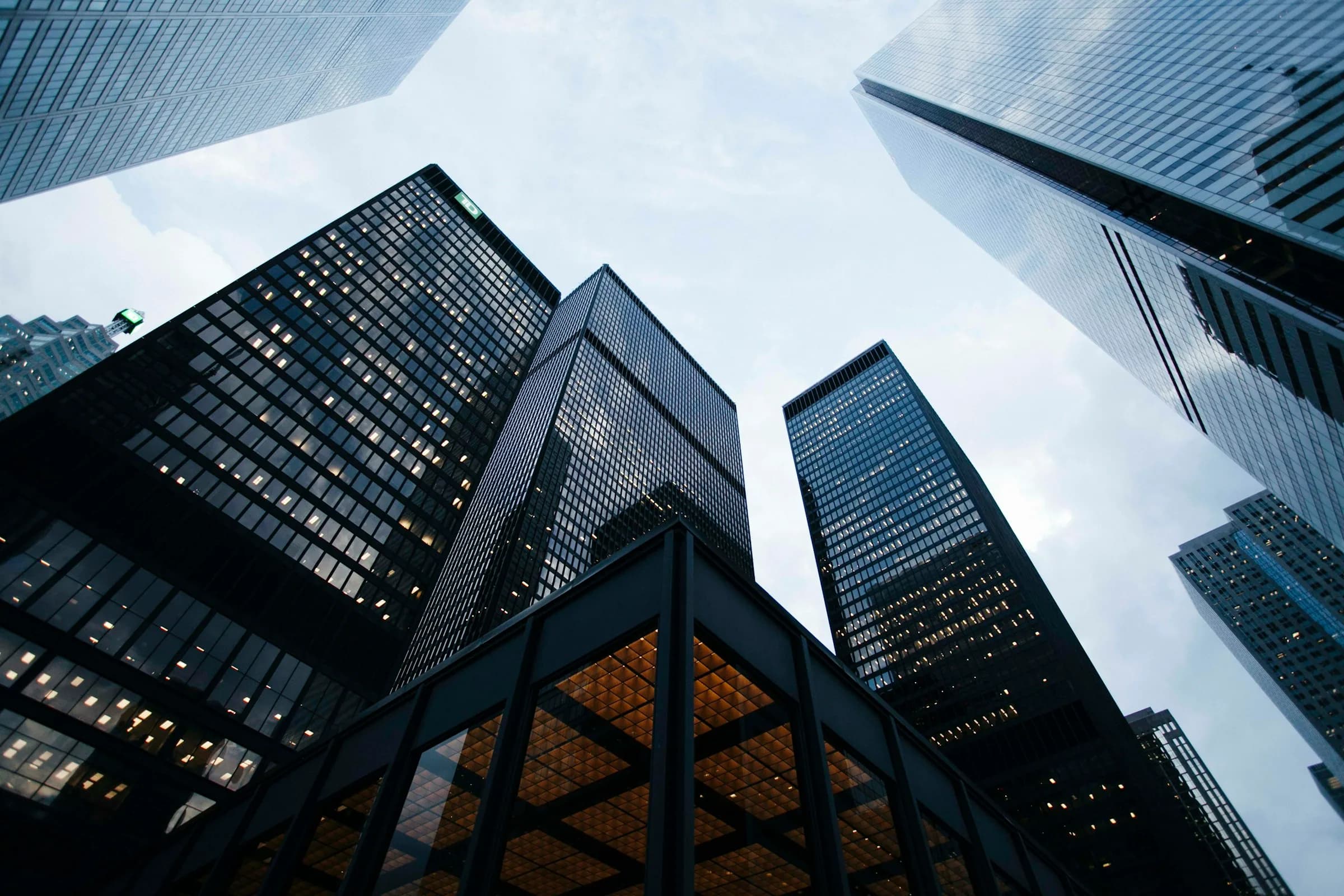 Glass towers seen from below, dark structural grid with lit windows